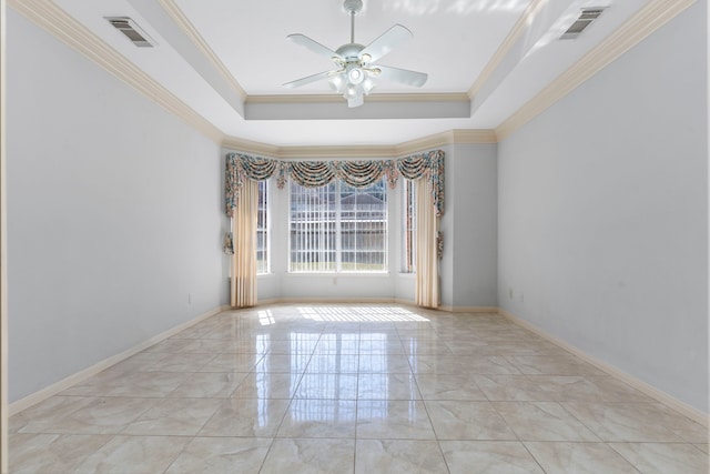 empty room featuring a raised ceiling, visible vents, and crown molding