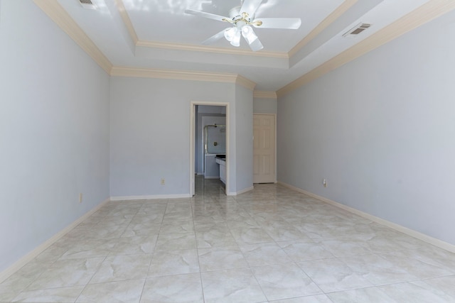 spare room featuring visible vents, a tray ceiling, ceiling fan, and ornamental molding