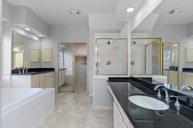 full bathroom featuring a shower stall, visible vents, two vanities, and a sink