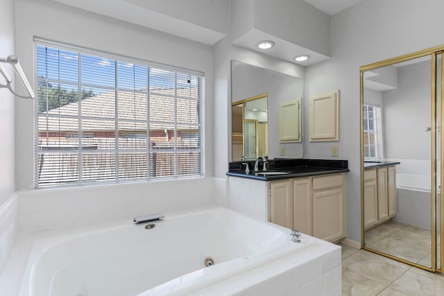 full bathroom featuring a wealth of natural light, vanity, and a whirlpool tub