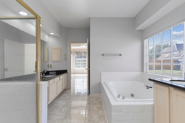 full bath with two vanities, ceiling fan, a sink, a whirlpool tub, and tile patterned floors