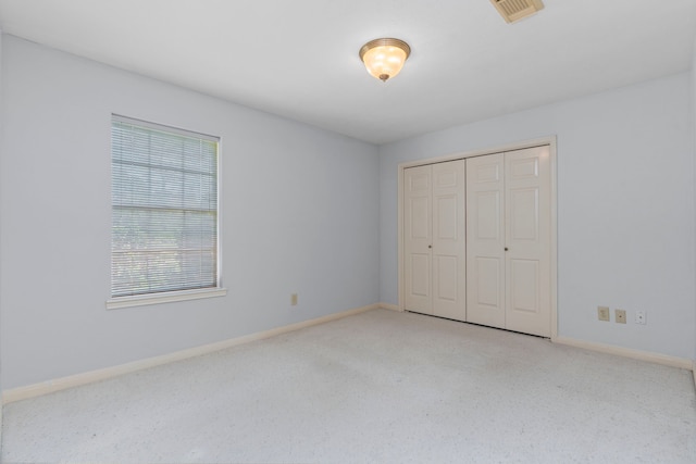 unfurnished bedroom with baseboards, visible vents, a closet, and light colored carpet