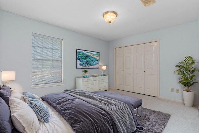 bedroom featuring carpet floors, a closet, visible vents, and baseboards