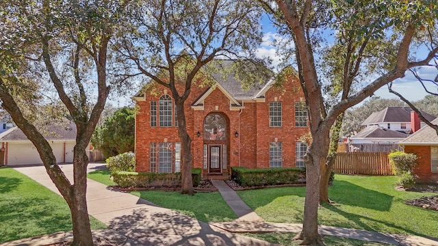 traditional-style home featuring brick siding, a front yard, and fence