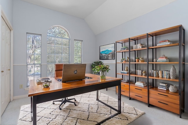 office space featuring lofted ceiling and baseboards