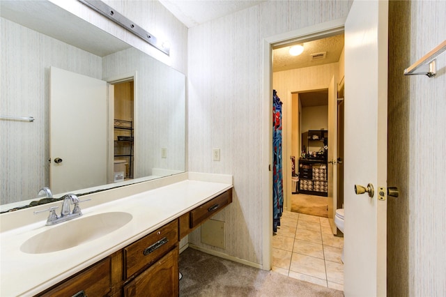 bathroom with tile patterned floors, vanity, a textured ceiling, and toilet