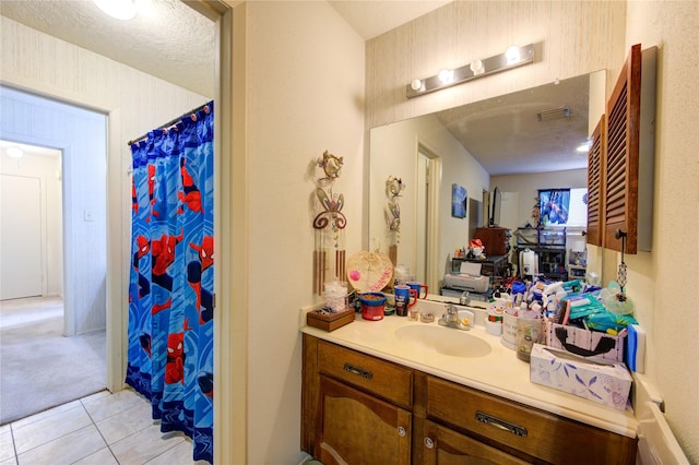 bathroom featuring tile patterned floors, vanity, curtained shower, and a textured ceiling