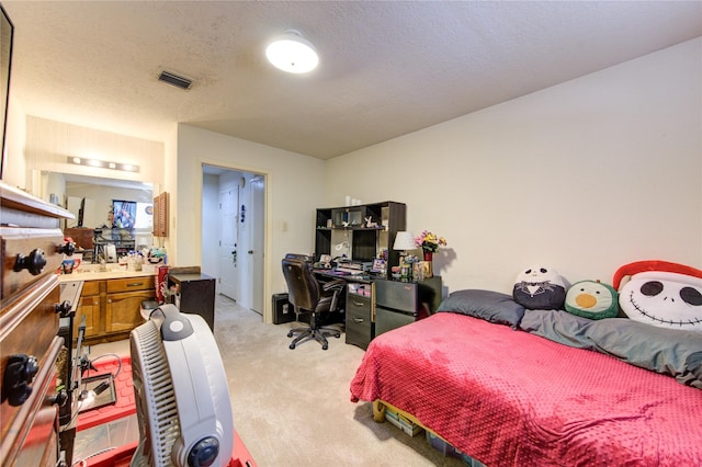 bedroom with a textured ceiling and light colored carpet