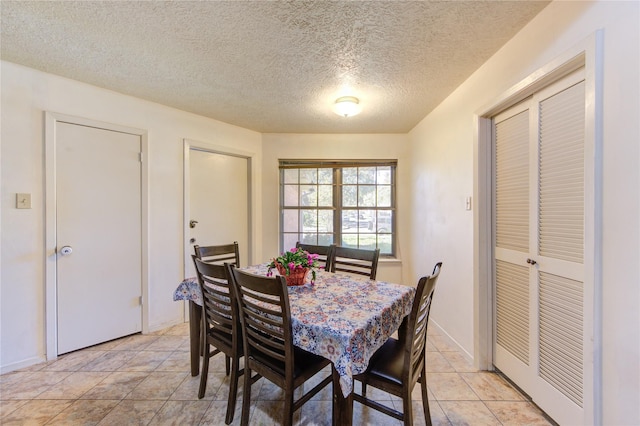 dining space with light tile patterned floors and a textured ceiling