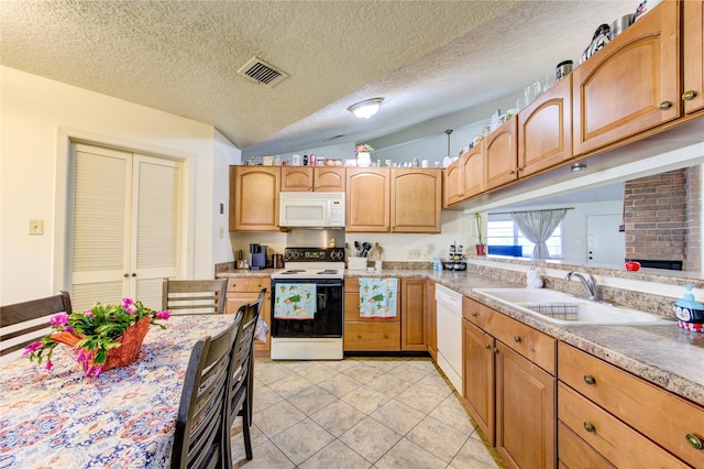 kitchen featuring a textured ceiling, white appliances, sink, lofted ceiling, and light tile patterned flooring