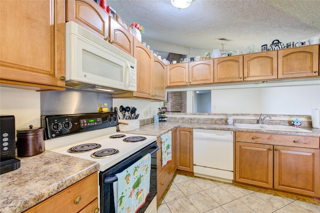 kitchen featuring a textured ceiling, white appliances, light tile patterned floors, and sink