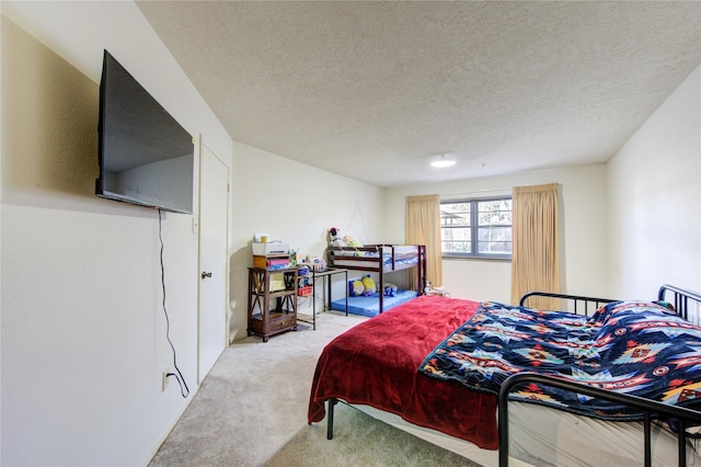 bedroom with light carpet and a textured ceiling