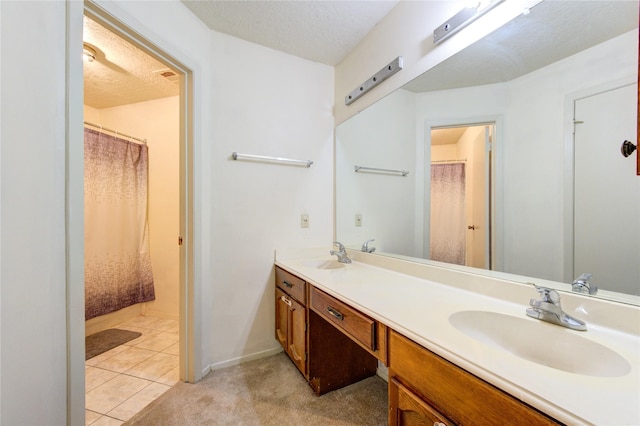 bathroom featuring tile patterned flooring, vanity, and a textured ceiling