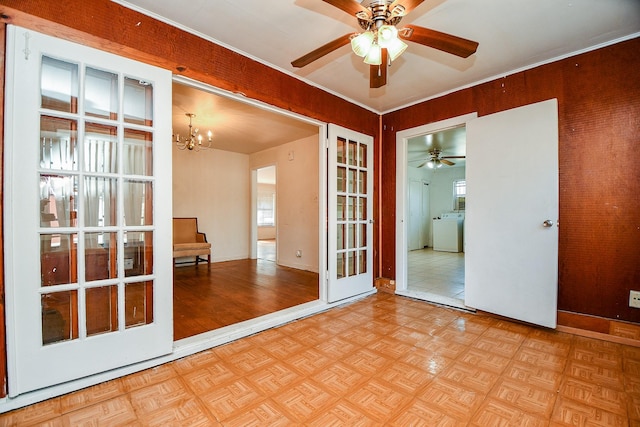 empty room featuring ceiling fan with notable chandelier, washer / clothes dryer, and light parquet flooring