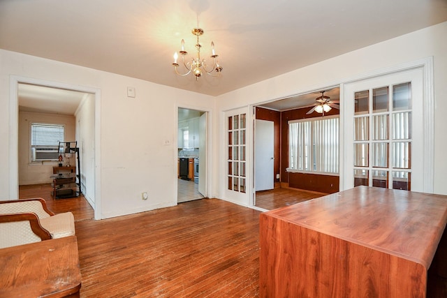 unfurnished dining area featuring french doors, plenty of natural light, hardwood / wood-style floors, and ceiling fan with notable chandelier