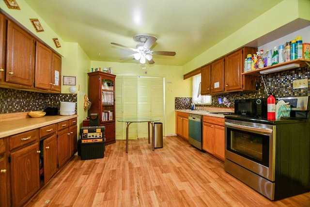 kitchen featuring appliances with stainless steel finishes, backsplash, light hardwood / wood-style flooring, and ceiling fan