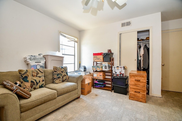 sitting room with ceiling fan and light colored carpet