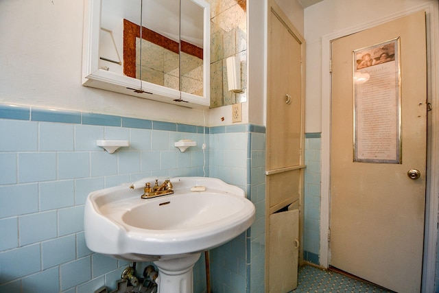 bathroom featuring sink and tile walls