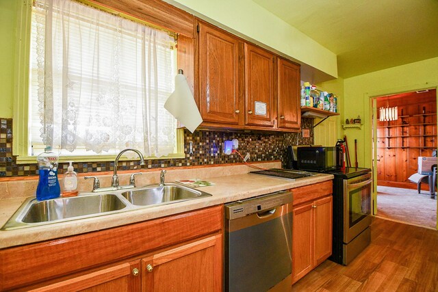 kitchen featuring sink, decorative backsplash, a healthy amount of sunlight, dark hardwood / wood-style flooring, and stainless steel appliances