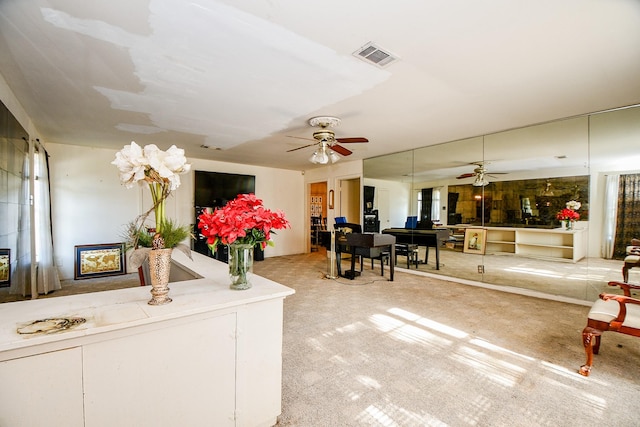 carpeted living room with ceiling fan