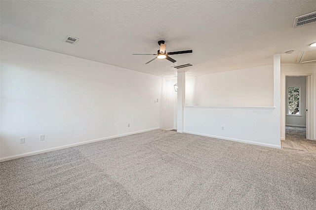 carpeted empty room featuring ceiling fan and a textured ceiling