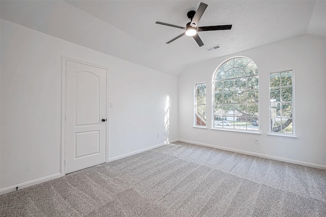 carpeted empty room with a textured ceiling, ceiling fan, and vaulted ceiling