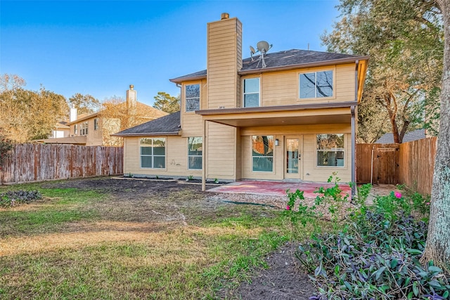 back of property featuring a patio area and a yard