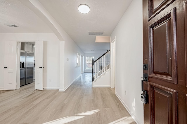 entrance foyer with light hardwood / wood-style flooring and a textured ceiling