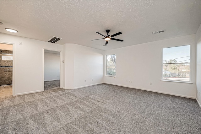 unfurnished room featuring ceiling fan, carpet, and a textured ceiling