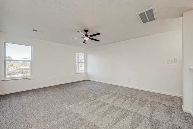 carpeted spare room featuring a textured ceiling and ceiling fan