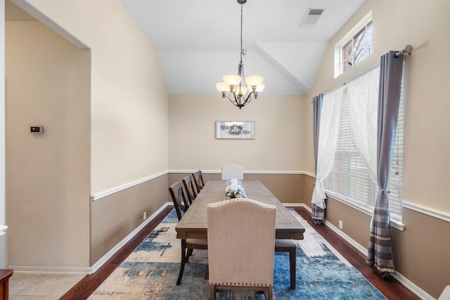 dining space featuring a chandelier, dark hardwood / wood-style floors, vaulted ceiling, and a wealth of natural light