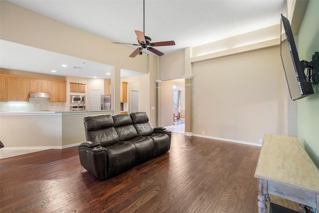 living room featuring ceiling fan and dark wood-type flooring