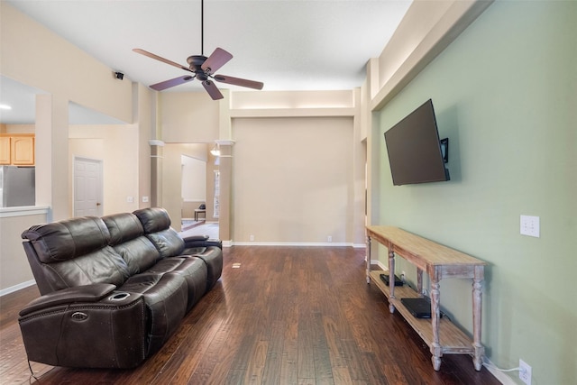 living room with ceiling fan and dark wood-type flooring