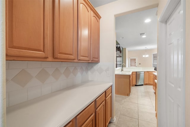 kitchen with tasteful backsplash, sink, light tile patterned floors, an inviting chandelier, and hanging light fixtures