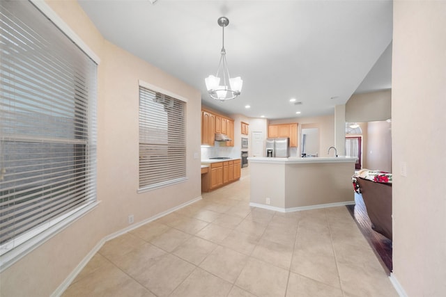 kitchen with backsplash, a chandelier, pendant lighting, light tile patterned floors, and appliances with stainless steel finishes