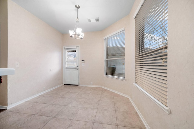 unfurnished dining area with light tile patterned floors and a chandelier