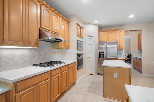 kitchen with a kitchen island, light tile patterned floors, appliances with stainless steel finishes, and tasteful backsplash