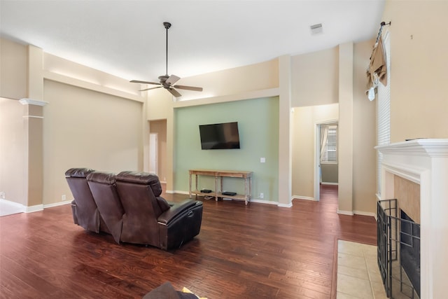 living room featuring a fireplace, dark hardwood / wood-style floors, and ceiling fan