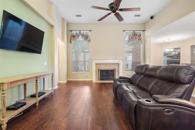 living room featuring a fireplace, ceiling fan, and dark wood-type flooring