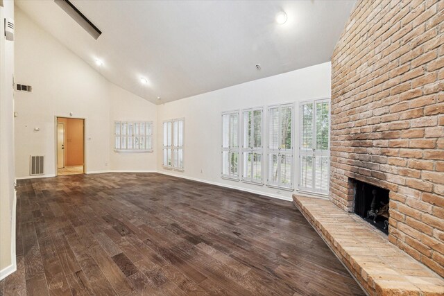 unfurnished living room with high vaulted ceiling, dark hardwood / wood-style floors, and a brick fireplace