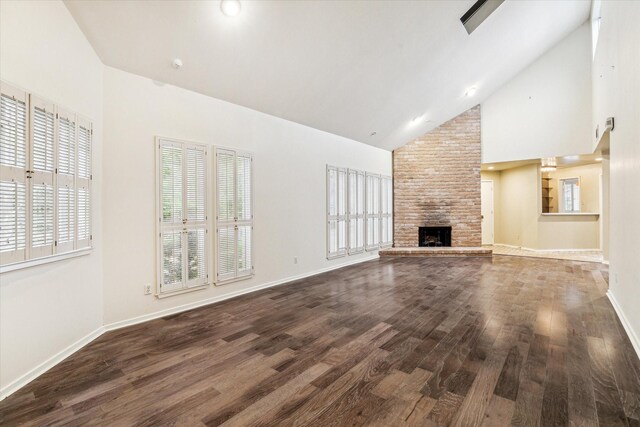 unfurnished living room featuring wood-type flooring, a large fireplace, and high vaulted ceiling