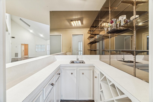 kitchen featuring sink, white cabinets, and vaulted ceiling