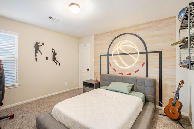 carpeted bedroom with wooden walls