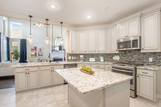 kitchen featuring light stone counters, a center island, sink, and stainless steel appliances