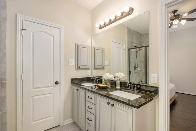 bathroom with hardwood / wood-style floors, vanity, ceiling fan, and a shower with shower door