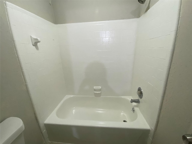 bathroom with washtub / shower combination and toilet