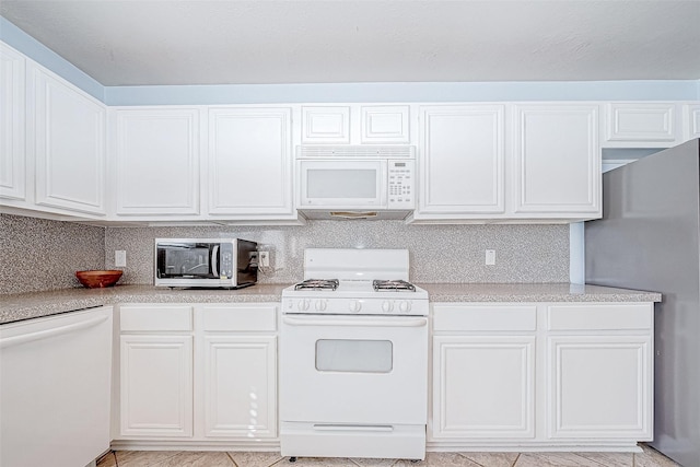 kitchen featuring backsplash, white cabinets, light tile patterned flooring, and appliances with stainless steel finishes