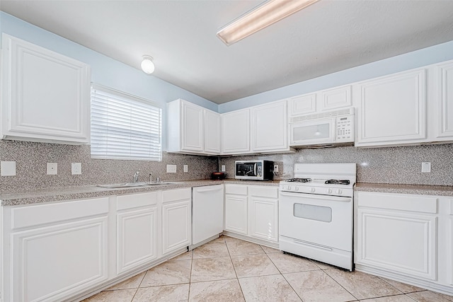 kitchen featuring sink, white cabinets, light tile patterned flooring, and white appliances