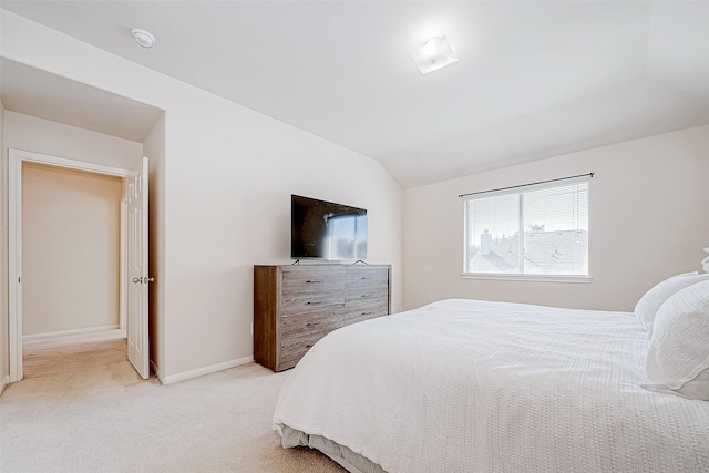 bedroom with light carpet and lofted ceiling