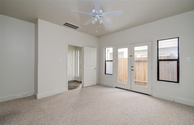 carpeted empty room with ceiling fan and french doors